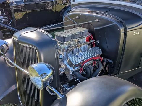 Gray hot rod with open engine and custom metal body glistens Фото