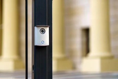 Gray intercom with camera and call button on metal rod Stock Photos