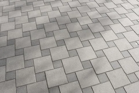 Gray interlocking paving stones arranged in a geometric pattern on a flat s.. Stock Photos
