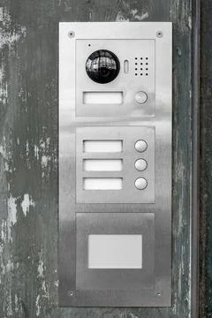 Gray iron intercom with call buttons and a camera with a speaker outdoor. Stock Photos