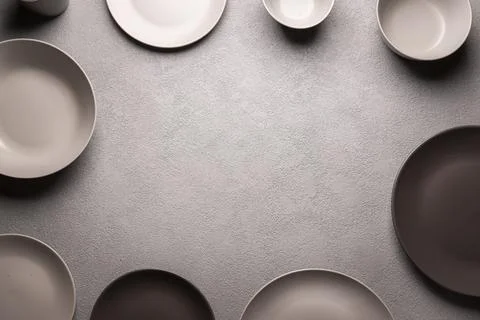 A gray kitchen dining table framed with plates and bowls. a menu concept for a Stock Photos