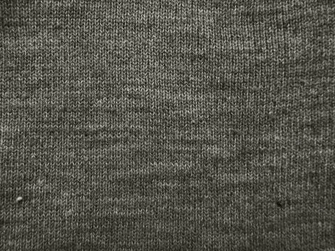 Gray knitted fabric texture macro close up intricate wool yarn stitch patte.. Stock Photos