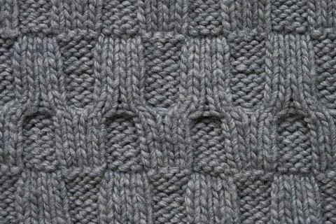 Gray knitted texture with a relief pattern. Handmade Knitwear. Background Stock Photos