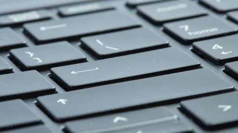 Gray laptop keyboard close-up. Selective focus on enter buttons. Stock Photos