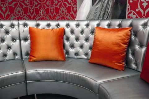 Gray leather sofa with red pillows Stock Photos