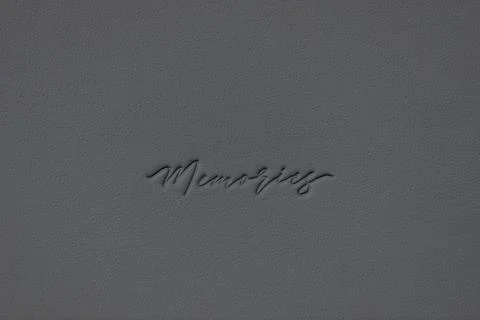 Gray leather texture close-up with the word memories embossed Stock Photos