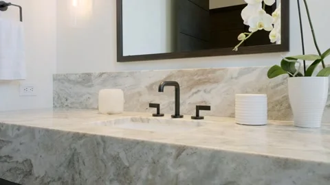 Gray marble vanity table with sink and black matte faucet decorated with live Stock Footage 265173363