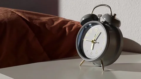 Gray mechanical clock goes standing on the bedside table Stock Footage 238704643