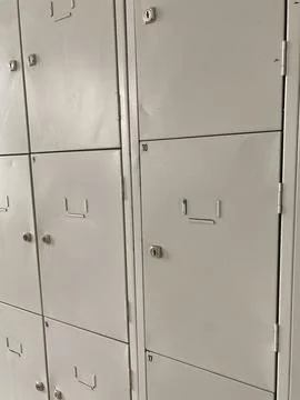 Gray metal lockers arranged in rows, featuring secure locks and numbered doors Stock Photos
