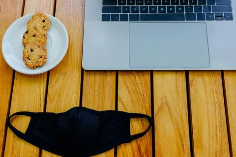 Gray modern laptop to work. Time for a coffee break. Black mask to protect Stock Photos