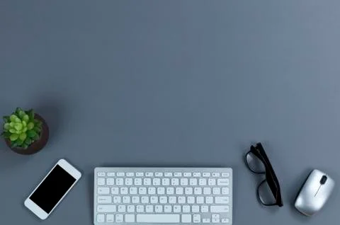 Gray office working desktop with wireless technology and plant. Plenty of cop Stock Photos