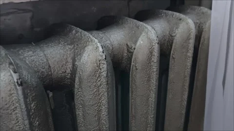A gray old battery in the room. An old radiator in the house Видео 313651978