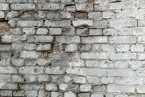 Gray old textured brick wall with cracks for background Stock Photos