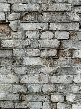 Gray old textured brick wall with cracks for background Stock Photos