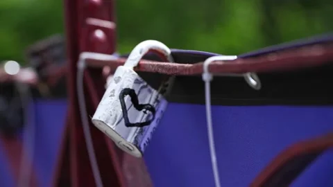 Gray padlock with a painted heart on the bridge of lovers. romantic symbol of lo Stock Footage 232898454