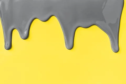 Gray paint leaking down yellow background. Stock Photos