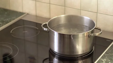 A gray pan in which water is boiling stand on an electric glass stove in kitchen Stock Footage 140336561