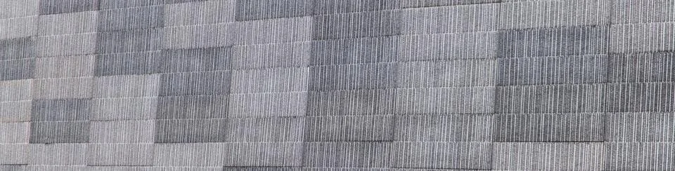 Gray patchwork concrete wall with horizontal squares Fotos de archivo