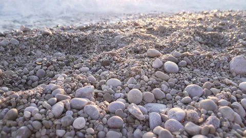 Gray pebbles on the beach at sunset sunrise. Sea shore. Ocean coast waves UHD Stock Footage 125424677