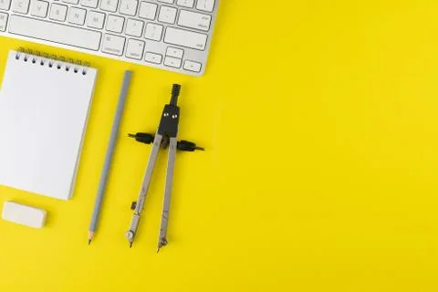 Gray pencil and notepad planner, keyboard, erase rubber, divider on yellow ba Stock Photos