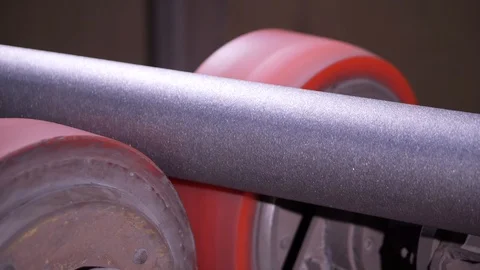 Gray pipe is rotating on the transporter line in the workshop at factory. Stock Footage 121588807