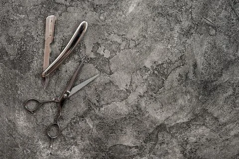 On a gray, plaster background is razor and scissors. Stock Photos