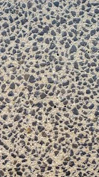 Gray plaster on the wall with fine black pebbles Stock Photos