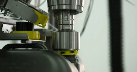 Gray plastic bottles move along a conveyor line to fill and pack motor oil. Stock Footage 166284726