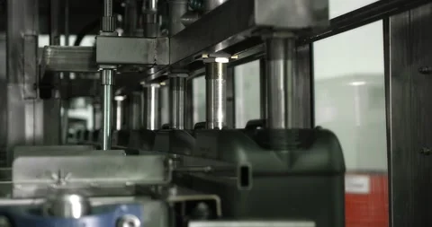 Gray plastic bottles move along a conveyor line to fill and pack motor oil. Stock Footage 166285621