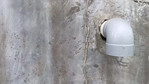 Gray plastic drainage pipe on stained concrete wall. Industrial, plumbing, const Видео 335065172