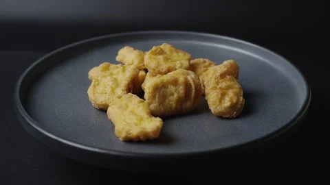 A gray plate is rotating in the frame, chicken nuggets are on the plate.  Stock Footage 304535089