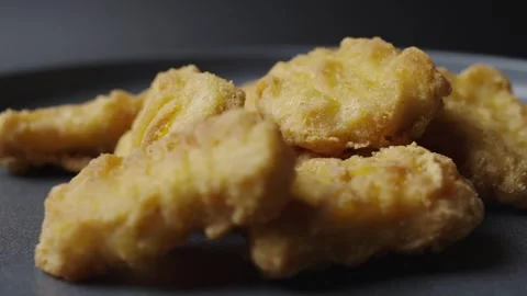 A gray plate is rotating in the frame, chicken nuggets are on the plate.  Stock Footage 304535837