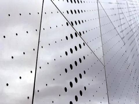 Gray plate surface with large and small holes, background Stock Photos