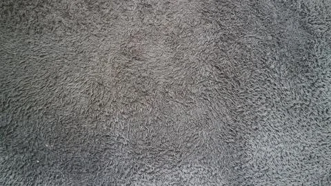Gray plush carpet presenting a soft, shaggy texture, providing warmth and c.. Stock Photos