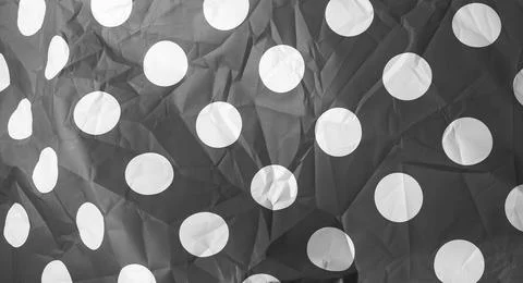 Gray polka dot paper texture background. White circle pattern on dark crumple Stock Photos