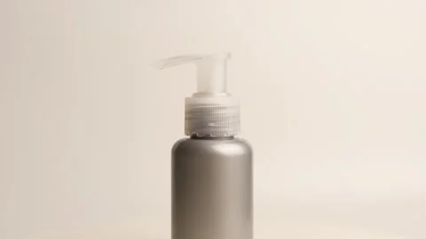 Gray pump bottle with blank label on rotating table display Vidéo 318170469