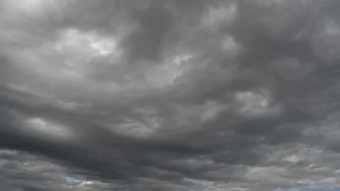 Gray rain clouds move through the sky in this time-lapse with areas of dark blue Stock Footage 309039186