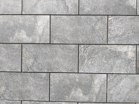 Gray rectangular stone wall with dark grout lines Stock Photos