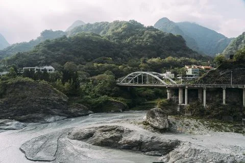 Gray river with bridge and mountains behind in Taroko National Park, Taiwan. Stock Photos