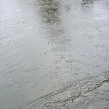 Gray river surface with ripple rings created by falling raindrops Stock Photos