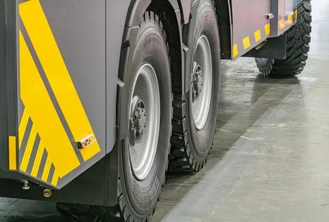Gray, robust truck on reflective concrete floor Angular design with black tre Stock Photos