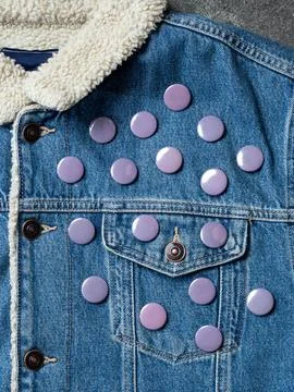 Gray  round badge button on denim jacket. Badge on a  jacket close-up view. T Stock Photos