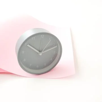 Gray round clock on a pink background. Mock-up Stock Photos