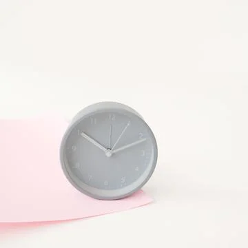 Gray round clock on a pink background. Mock-up Stock Photos
