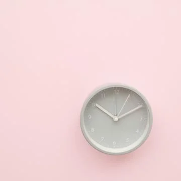 Gray round clock on a pink background. Mock-up Stock Photos
