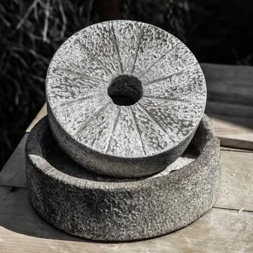 Gray round stone traditional hand mill grinding grain flour production Foto stock