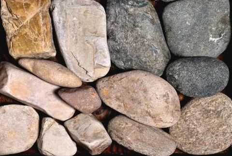 Gray rounded stones of heterogeneous structure, background Stock Photos