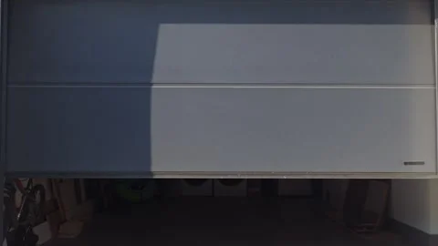 Gray sectional garage door is opening with storage items visible inside Video stock 333484403
