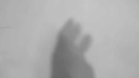 The gray shadow of a hand is clapping the pink wall. Stock Footage 251413766