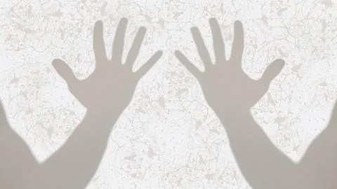 Gray shadows of two open hands on white inky background Stock Photos